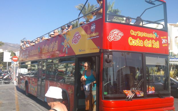 Curious tourist stepping off the city sightseeing bus, eager to explore the wonders of Benalmadena's attractions and culture.